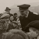 Kong Haakon besøker flyktninger fra Sørøya i Finnmark, evakuert til "Sørøy Camp" utenfor Glasgow 1945. Foto: Offisielt foto, NTB - De kongelige samlinger.